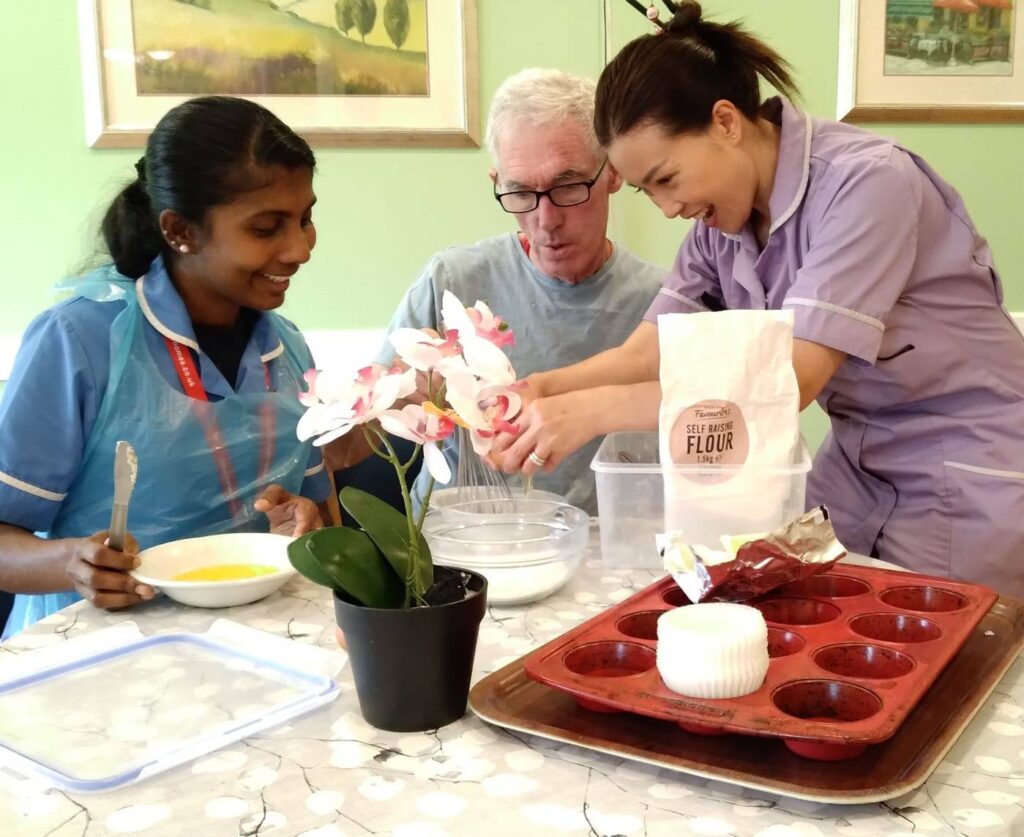 Resident enjoying baking with carers