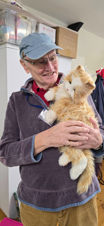 older gentleman holding a stuffed cat