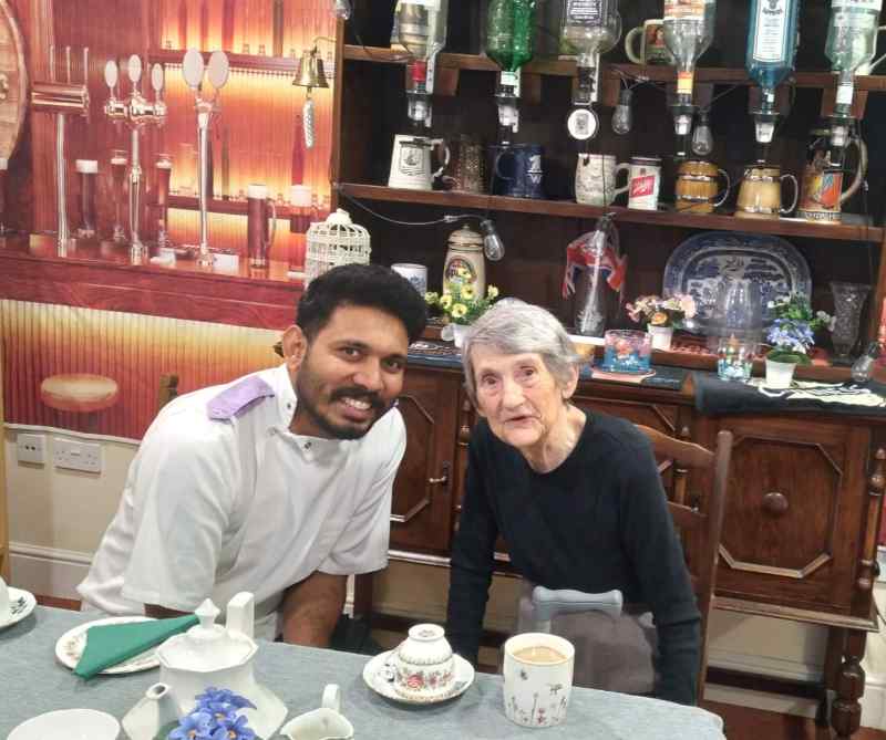 Resident and carer having coffee